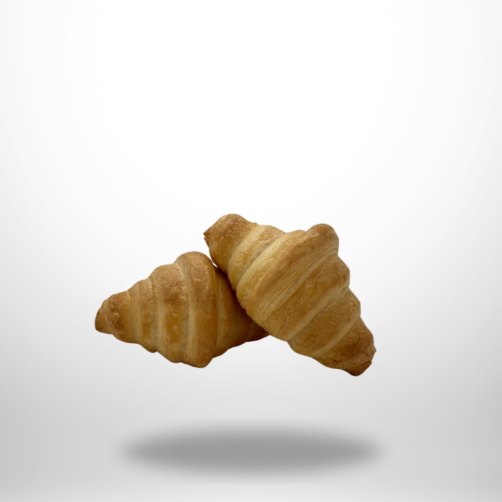 Zwei goldbraune, glutenfreie vegane Croissants von Lucky Grain auf hellem Untergrund, zartsplittrige Schichten sichtbar.
