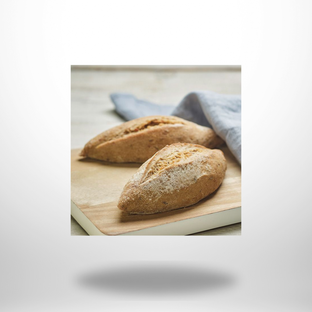 Zwei frisch gebackene Steinofen-Vesperstangen von Hammermühle mit rustikaler Kruste, bestreut mit Kümmel und Fenchel, auf Holzbrett.